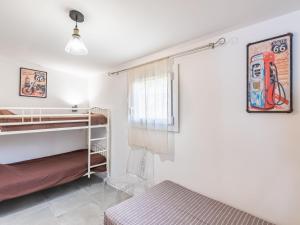 ein Schlafzimmer mit Etagenbetten und einem Fenster in der Unterkunft Holiday Home Polpu by Interhome in Sari Solenzara