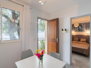 a room with a table with a vase of flowers on it at Holiday Home Signoria by Interhome in Sari Solenzara