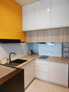 a kitchen with white cabinets and a sink at #MickiewiczaApartment in Giżycko