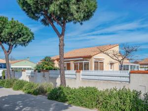 una casa con una recinzione bianca e alberi di Villa Ladine by Interhome a Le Barcarès