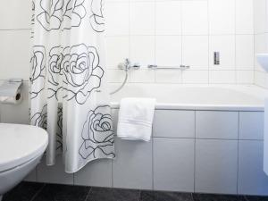 a bathroom with a tub and a toilet and a shower curtain at Apartment Chesa Corvatsch 111 - Champfer by Interhome in Surlej