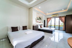Habitación de hotel con 2 camas y balcón en OYO 75377 Check In House, en Suratthani