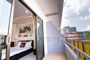 Un pequeño balcón con una cama en un edificio en OYO 75377 Check In House, en Suratthani