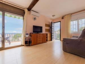 a living room with a tv and a large window at Apartment Regina by Interhome in Torredembarra