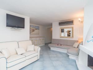 a living room with two white couches and a tv at Holiday Home Omer by Interhome in San Teodoro