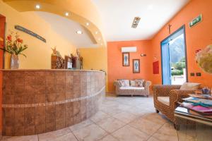 vestíbulo con paredes de color naranja y mostrador de recepción en Hotel Altamarea, en San Vito lo Capo