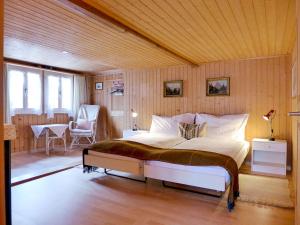 a bedroom with a bed and a table and chairs at Holiday Home Chalet Esther by Interhome in Brienz