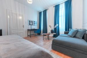 1 dormitorio con cama, sofá y escritorio en City Appartement WAGRAM am Hauptbahnhof, en Sankt Pölten