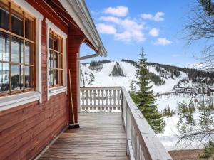 eine hölzerne Veranda eines Hauses mit Blick auf einen verschneiten Berg in der Unterkunft Holiday Home Iso kiiruna by Interhome in Hyrynsalmi
