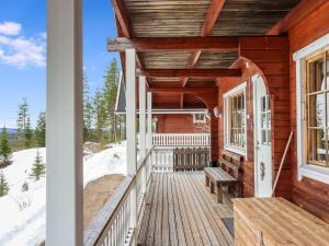 eine Veranda eines Holzhauses mit einer Bank in der Unterkunft Holiday Home Iso kiiruna by Interhome in Hyrynsalmi