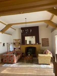 a living room with two couches and a fireplace at The Rose Barn, Ysgubor y Rhosyn in Llandysul