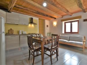 a kitchen and dining room with a wooden table and chairs at Chalet Rustico Rebustella by Interhome in Civo