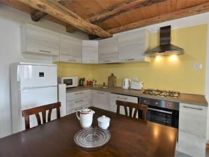 a kitchen with a wooden table and a white refrigerator at Chalet Rustico Rebustella by Interhome in Civo +29 photos