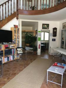 a living room with a staircase and a table and a tv at Maison d'hôtes naturiste Villa PaulAna in Cap d'Agde