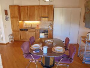 een keuken met een tafel en stoelen en een keuken met een tafel en een stoeltje bij Apartment les Vignettes by Interhome in Crans-Montana