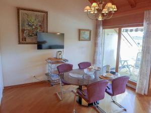 a dining room with a table and purple chairs at Apartment les Vignettes by Interhome in Crans-Montana
