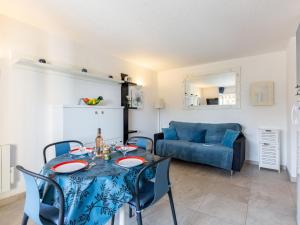 ein Wohnzimmer mit einem Tisch und einem blauen Sofa in der Unterkunft Apartment La Nuit de Mai-5 by Interhome in Saint-Aygulf