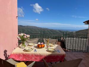 a table with fruit and flowers on a balcony at Apartment Le Volte by Interhome in Pantasina