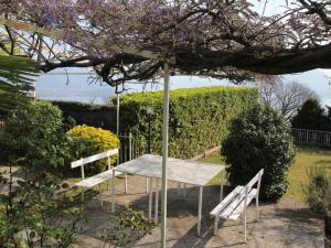 einen Tisch und zwei Bänke in einem Garten in der Unterkunft Holiday Home Pietro by Interhome in Stresa