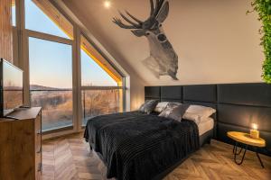 a bedroom with a bed with a deer head on the wall at Jaworowe Wzgórze Solina in Solina