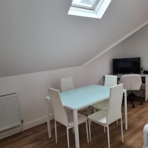 a dining room with a blue table and chairs at 2-Bed Loft Apartment for 5ppl with private parking in Beckenham