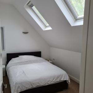 1 dormitorio con paredes blancas y 2 tragaluces en 2-Bed Loft Apartment for 5ppl with private parking en Beckenham