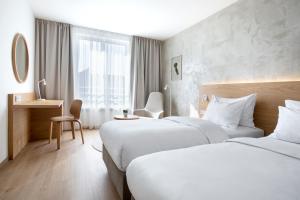 a hotel room with two beds and a window at Botanique Hotel Prague in Prague