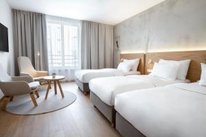 a hotel room with three beds and a chair at Botanique Hotel Prague in Prague