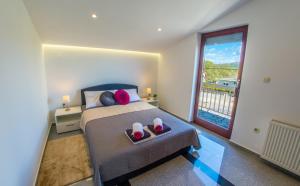 a bedroom with a bed with two candles and a balcony at Villa Plavota in Ljubuški