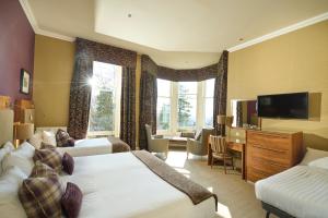 a hotel room with two beds and a flat screen tv at Crieff Hydro in Crieff