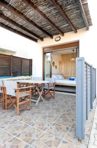 patio ze stołem, krzesłami i łóżkiem w obiekcie Memi Beach front Villa w mieście Kiotari