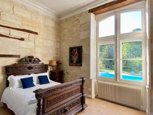 a bedroom with a bed and a large window at Château Borgeat de Lagrange - privatisation in Blaye