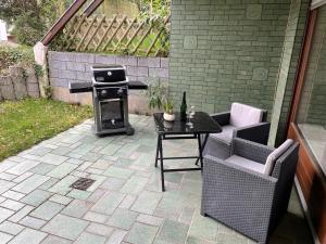 a patio with a grill and a table and chairs at Ferienwohnung Fröschenpuhl NEU in Traben-Trarbach