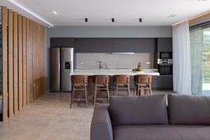 a kitchen with a couch and a kitchen island at Rock Bay Villas - Luxury Villas in Crete in Agia Pelagia
