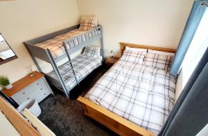 a bedroom with two bunk beds and a desk at The Lodge in Guyhirn