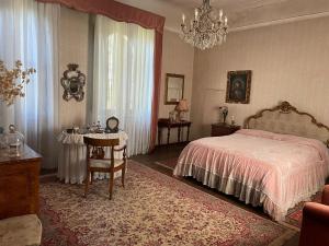 佛羅倫斯的住宿－CASA LA TORRE un castello alle porte di Firenze，卧室配有1张床、1张桌子和1把椅子