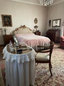 Un dormitorio con una cama y una mesa con una mesa. en CASA LA TORRE un castello alle porte di Firenze en Florencia