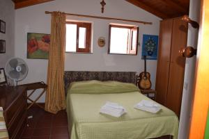 Un dormitorio con una cama verde y una guitarra en Casa Regina, en Gioiosa Marea