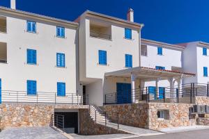 a large white building with blue shutters at Breakaway Apartment in Cres