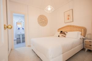 um quarto branco com uma cama e um lavatório em Pisoelpuerto em El Puerto de Santa Maria