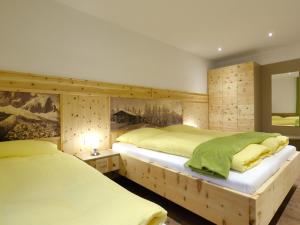 Dos camas en un dormitorio con paredes de madera. en Top holiday flat in Fügen near the ski area, en Fügen