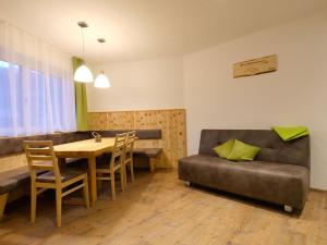 sala de estar con mesa y sofá de cuero en Top holiday flat in Fügen near the ski area, en Fügen