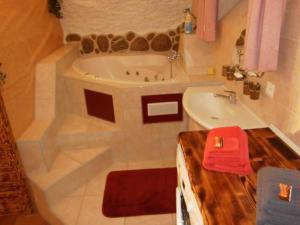 a bathroom with a tub and a sink at Casa Job - Gasthaus - Sauna, Whirlpool - Trun in Trun +8 photos