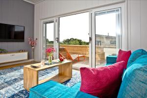 a living room with a blue couch and a table at Batcombe Hollow, Strawberryfield Park in Cheddar