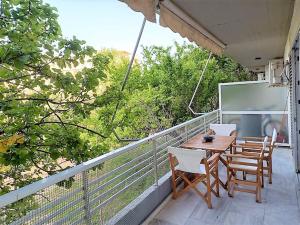 Un porche con una mesa y sillas en un balcón. en Apartments MARINA, en Porto Rafti