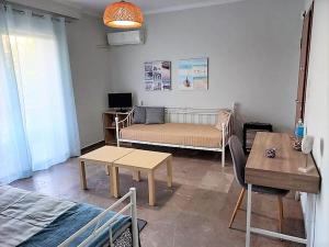 una sala de estar con una cama y una mesa en Apartments MARINA, en Porto Rafti