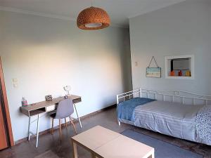 Un dormitorio con una cama, un escritorio y una mesa. en Apartments MARINA, en Porto Rafti