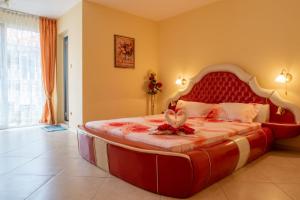 a bedroom with a large bed with a red headboard at Boutique Guest House 'Sofia' in Nesebar