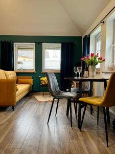 a dining room with green walls and a table and chairs at MK Hornik Apartament in Kowary