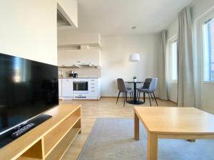 a kitchen and living room with a table and chairs at Tammer Huoneistot - City Suite 3 - Public Sauna, Gym & Pool in Tampere